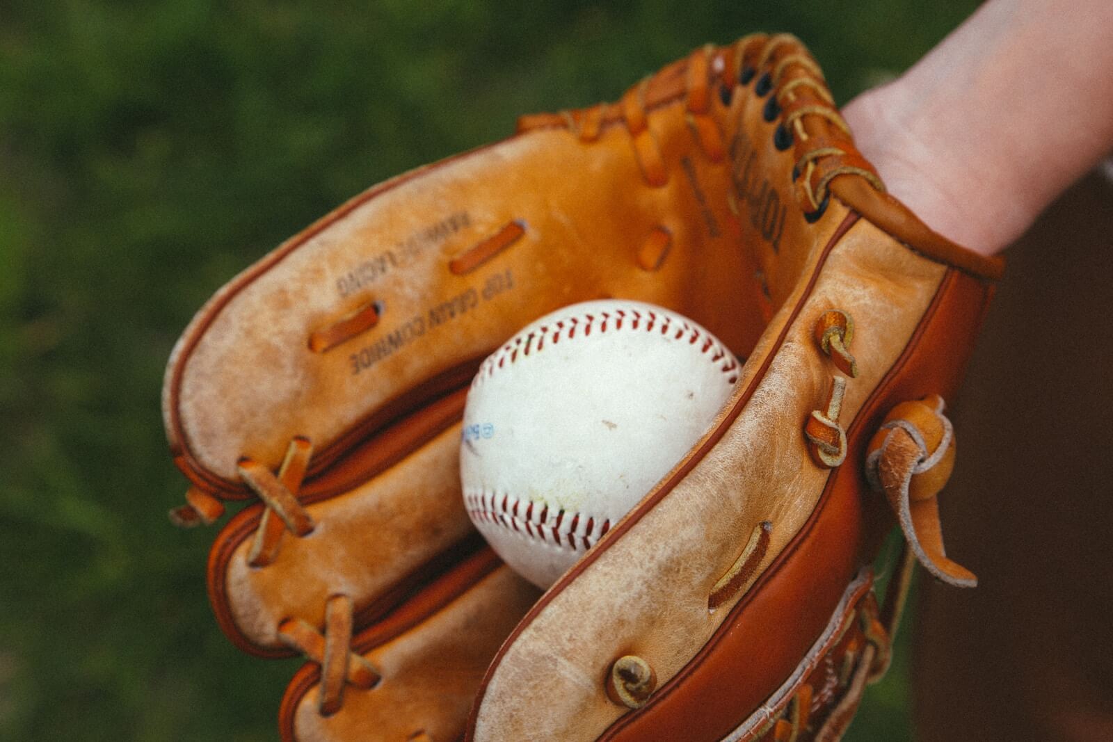 brown leather baseball mitt with white baseball